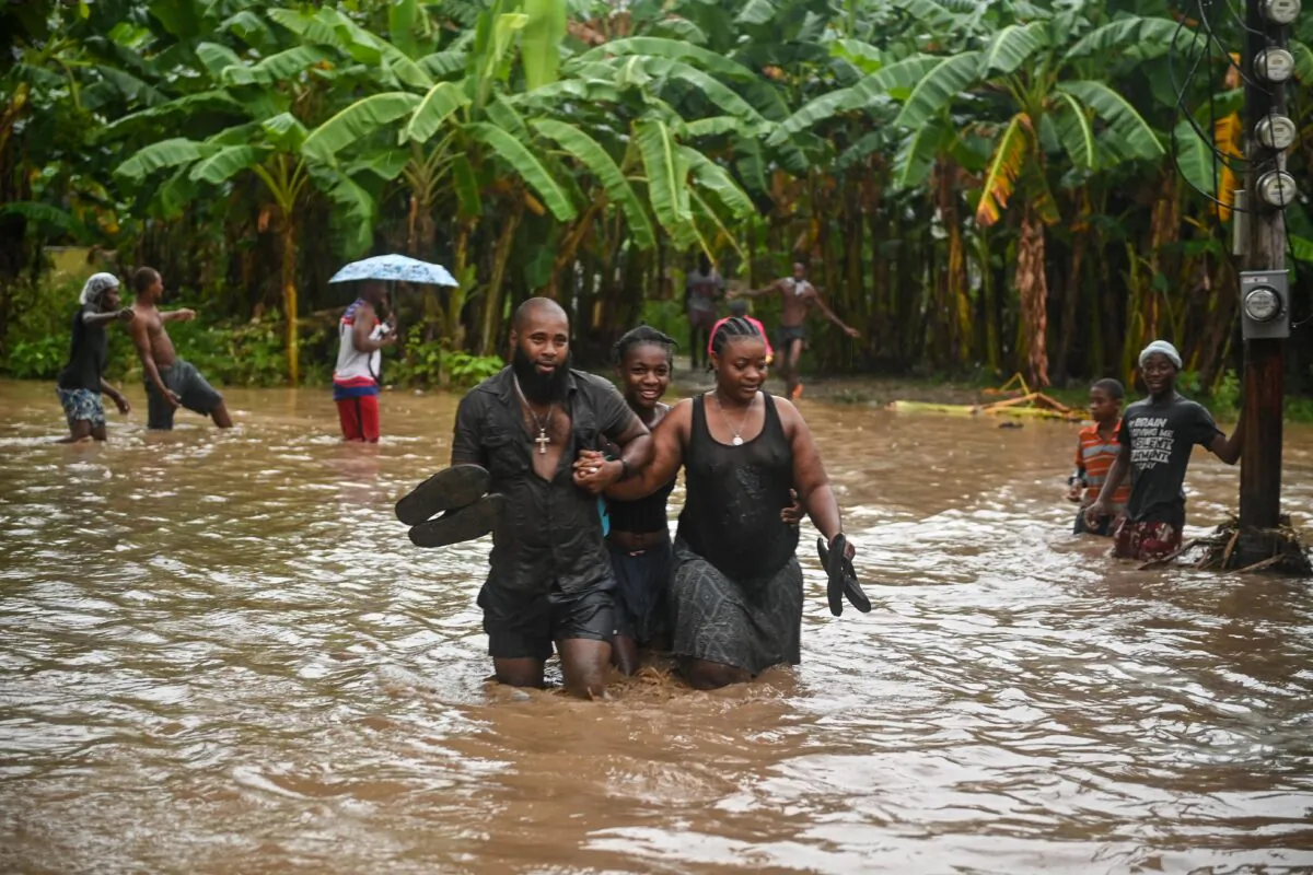 Resident wade through flooded roads in neighborhoods of Petit-Goâve, Haiti, on June 3, 2023. (Richard Pierrin/AFP via Getty Images)