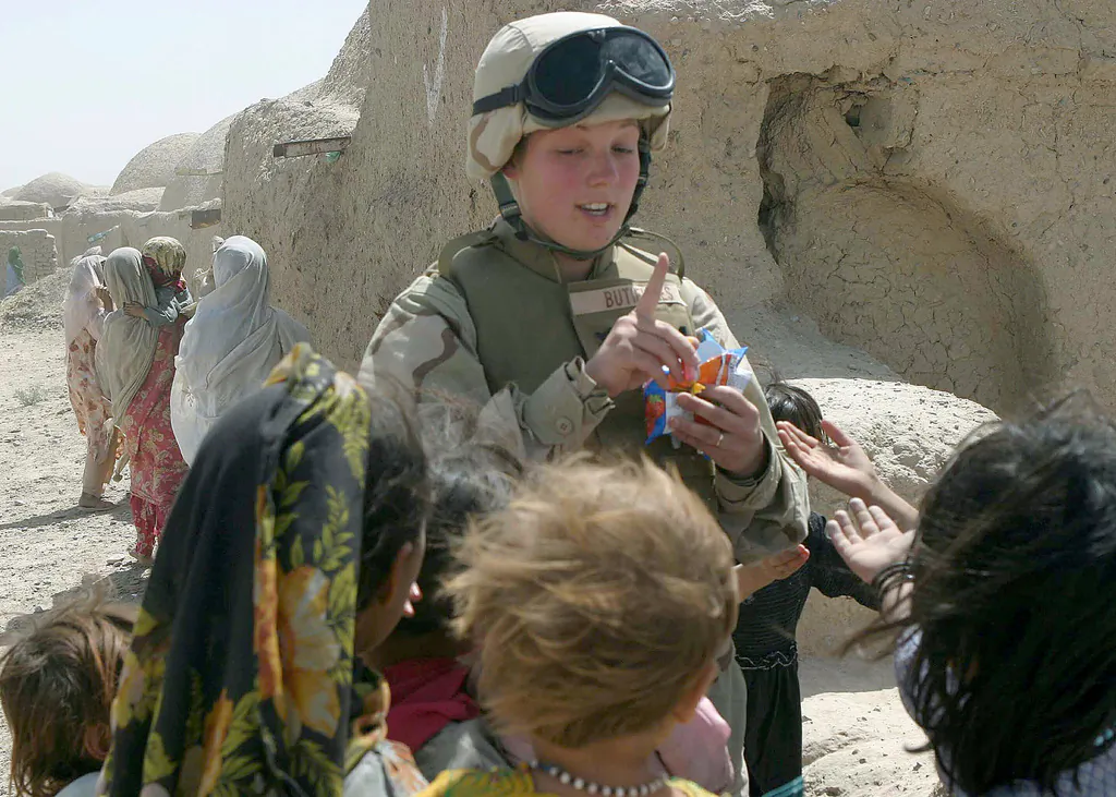 U.S. Navy Hospitalman Third Class Lori Butierries, 22nd Marine Expeditionary Unit (MEU), admonishes several Afghani children to be patient as they wait their turn for a piece of candy during a one-day Coalition Medical / Dental Civil Affairs Project humanitarian mission to the village of Najoy, Kandahar Province, Afghanistan, during Operation Enduring Freedom. (U.S. Marine Corps photo by Gunnery Sgt. Keith A. Milks)