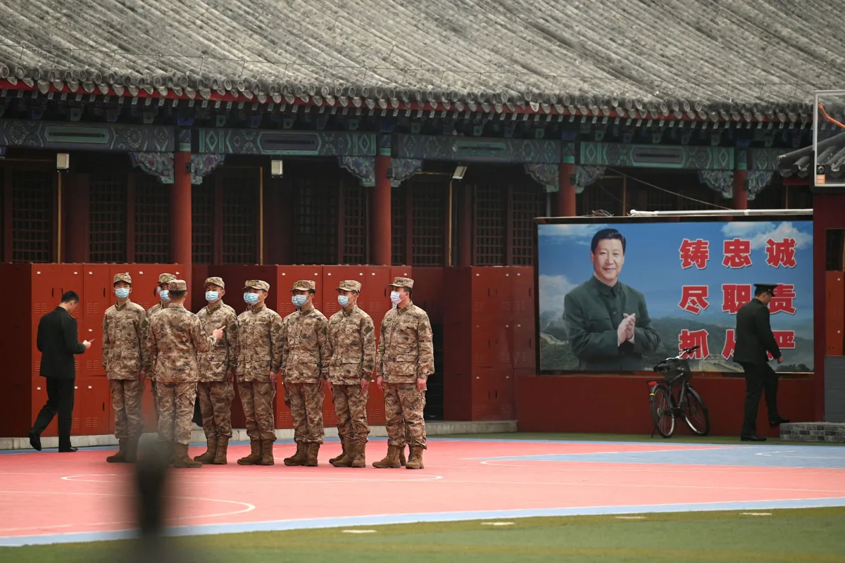 Security personnel stand guard at the entrance to the Forbidden City near an image of China's President Xi Jinping (R), as the closing session of the National Peoples Congress (NPC) takes place at the Great Hall of the People nearby in Beijing on March 11, 2022. (Photo by Noel Celis / AFP) (Photo by NOEL CELIS/AFP via Getty Images)