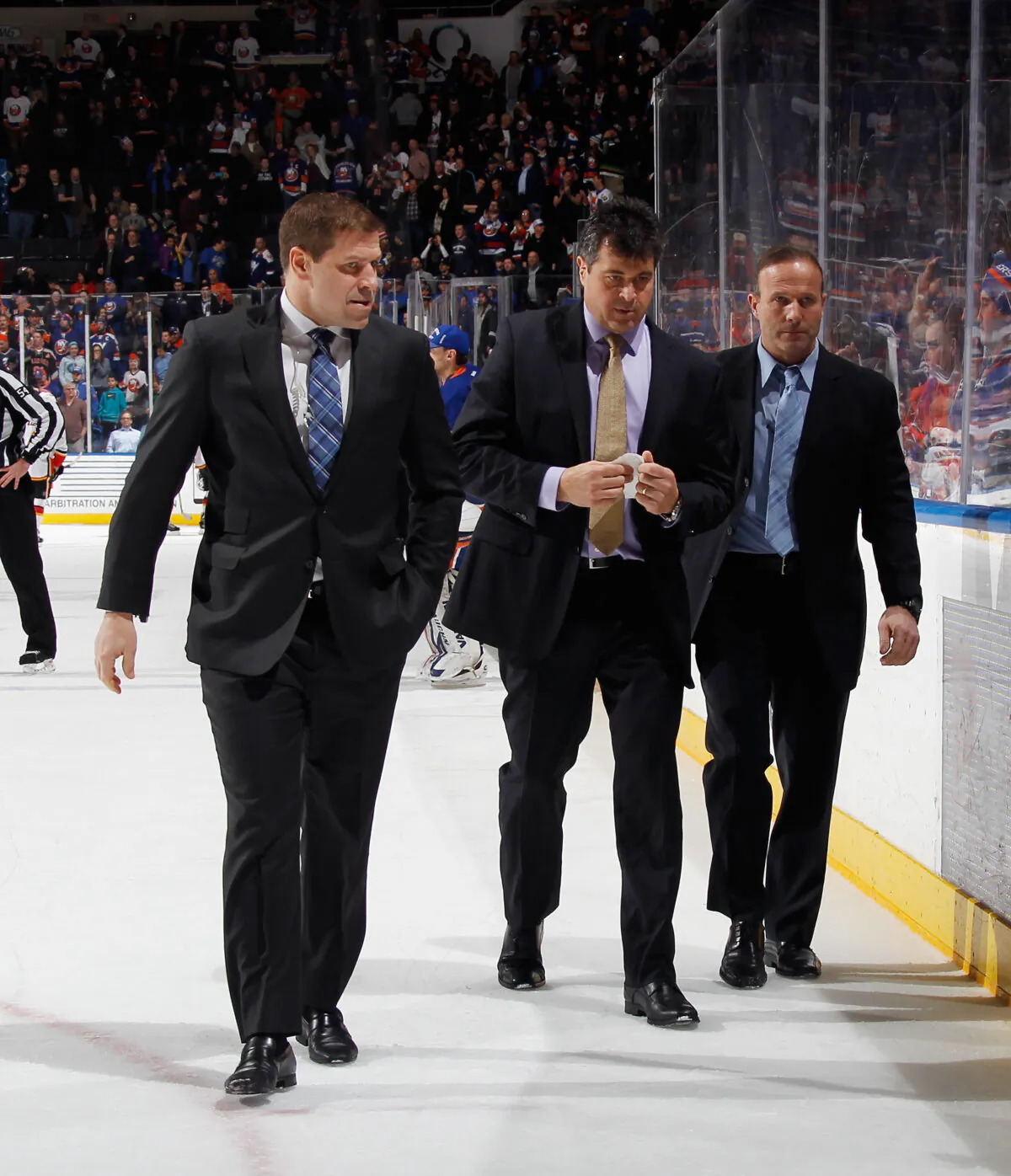 New York Islanders coaches (L) Doug Weight, Jack Capuano (C) and Greg Cronin (R) leave the ice following a 2–1 victory over the Calgary Flames at the Nassau Veterans Memorial Coliseum in Uniondale, N.Y., on Feb. 27, 2015. (Bruce Bennett/Getty Images)