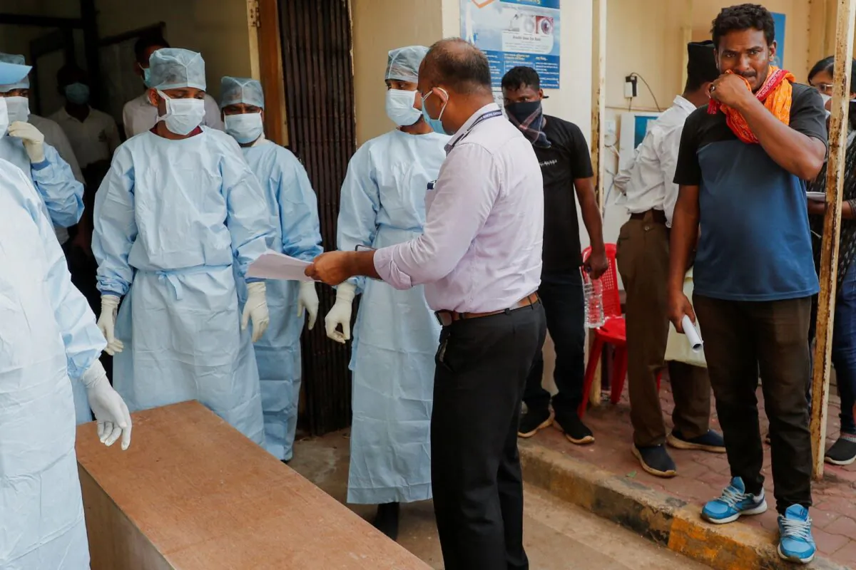 Dilip Kumar Sabar stands near a coffin with the body of his deceased brother-in-law Jyotilal Sabar, in the aftermath of a train collision in Balasore, at a hospital in Bhubaneswar in the eastern state of Odisha, India, on June 5, 2023. (Francis Mascarenhas/Reuters)