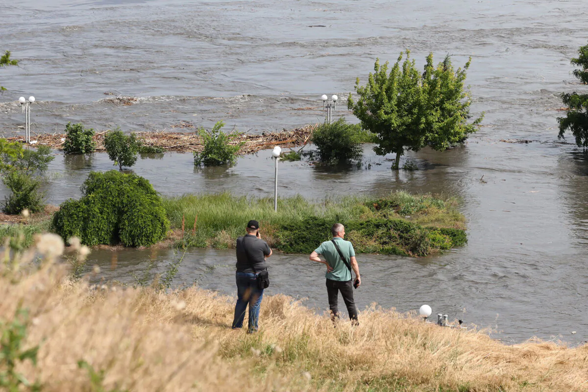 Local residents look at a partially flooded area of Kherson on June 6, 2023, following damage sustained at Kakhovka dam. The partial destruction unleashed a torrent of water that sent people fleeing flooding on the war's front line. (Stringer/AFP via Getty Images)