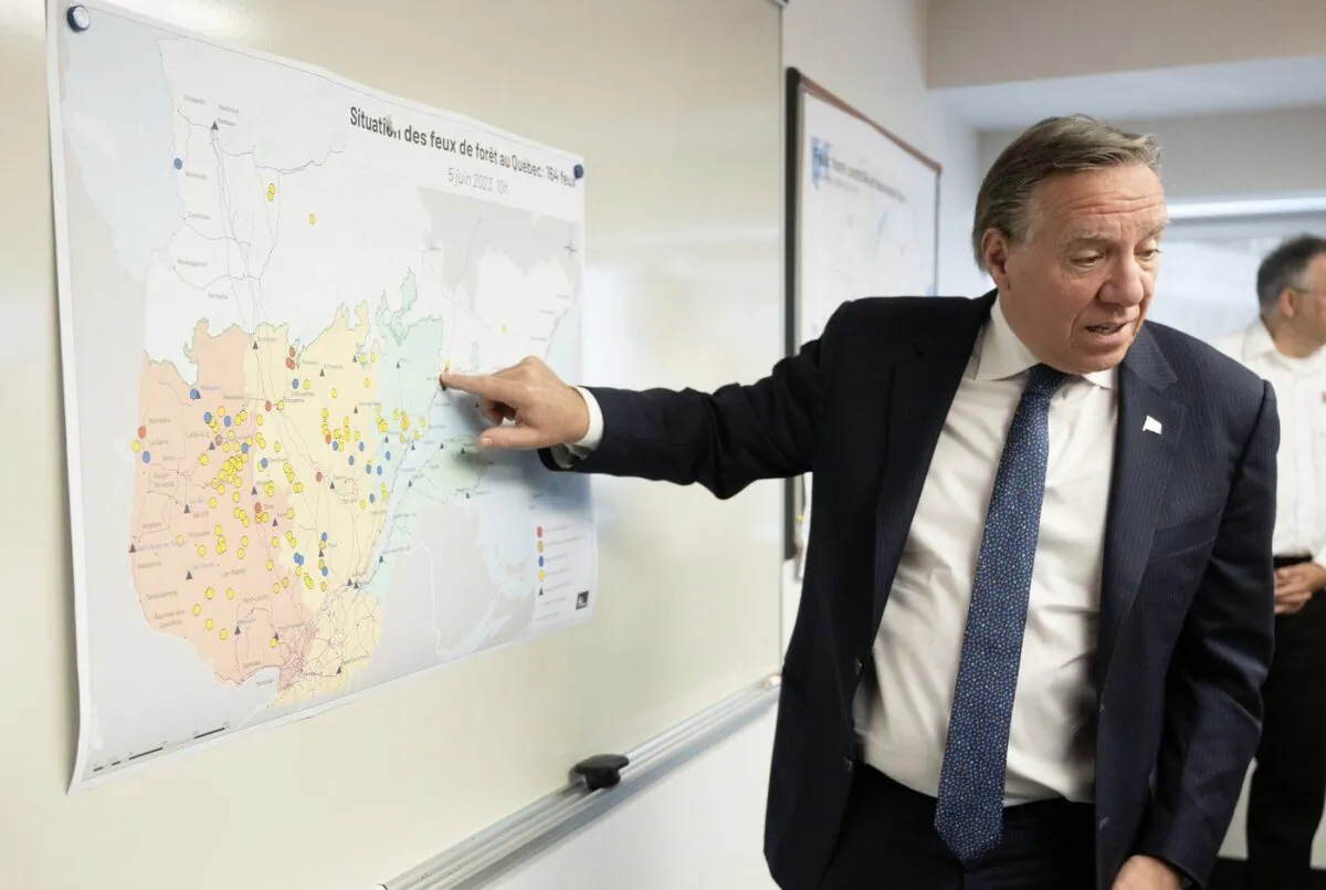 Quebec Premier Francois Legault checks the map where forest fires are raging as he visits the crisis operation centre, in Quebec City, June 5, 2023. (The Canadian Press/Jacques Boissinot)
