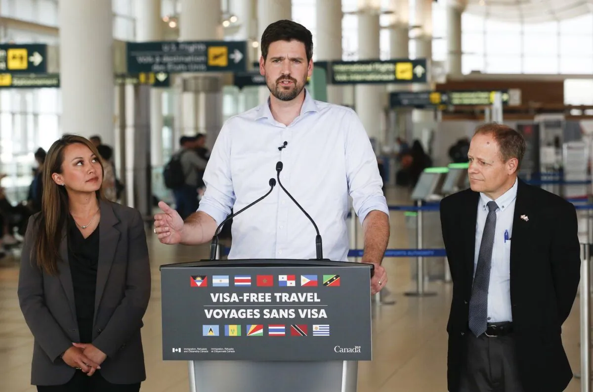 Sean Fraser, Minister of Immigration, Refugees and Citizenship, centre, Rechie Valdez, Member of Parliament for Mississauga, and Kevin Lamoureux, Member of Parliament for Winnipeg North, make an announcement regarding visa-free travel in the Winnipeg airport, June 6, 2023. (The Canadian Press/John Woods)
