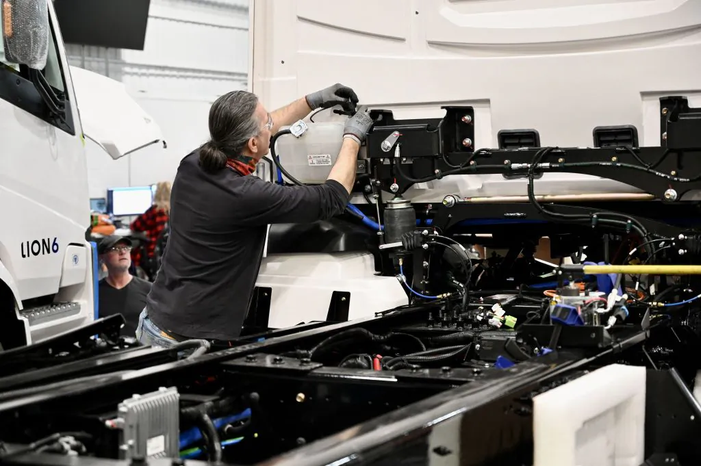 An employee works on the chassis of an electric truck at a factory in Quebec on March 15, 2023. (Derrick Cakpo/AFP via Getty Images)