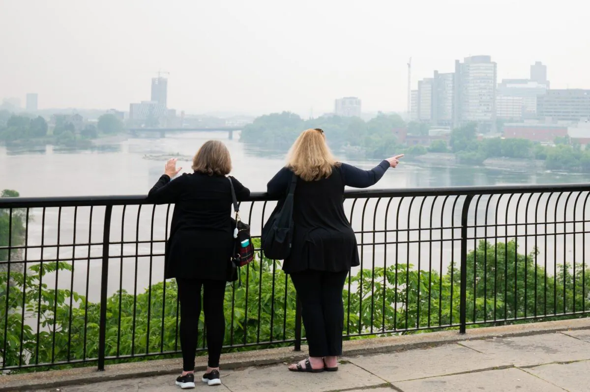 People look on from an observation platform as wildfire smoke engulfs the skyline in Ottawa, June 5, 2023. (The Canadian Press/Spencer Colby)
