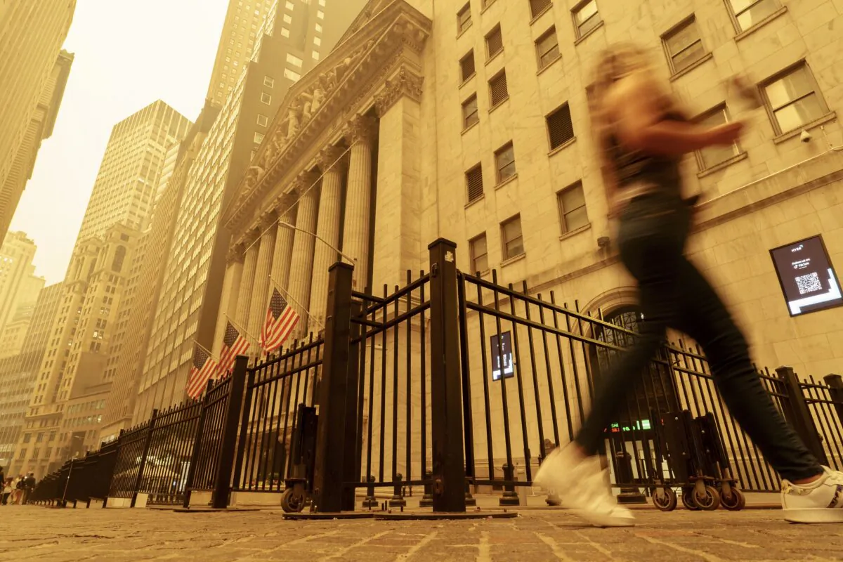 A pedestrian walks past the smoke and haze shrouded New York Stock Exchange building in New York on June 7, 2023. (J. David Ake/AP Photo)