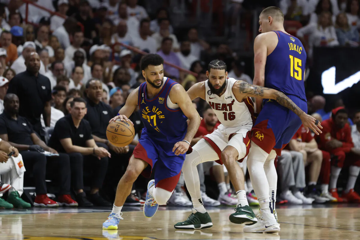 Jamal Murray (27) of the Denver Nuggets dribbles past a screen set by Nikola Jokic (15) against Caleb Martin (16) of the Miami Heat during the fourth quarter in Game Three of the 2023 NBA Finals at Kaseya Center  in Miami on June 7, 2023. (Mike Ehrmann/Getty Images)