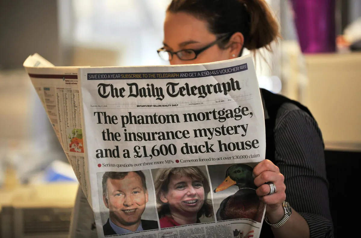 A woman reads a copy of The Daily Telegraph newspaper in London, on May 21, 2009. (Leon Neal/AFP via Getty Images)