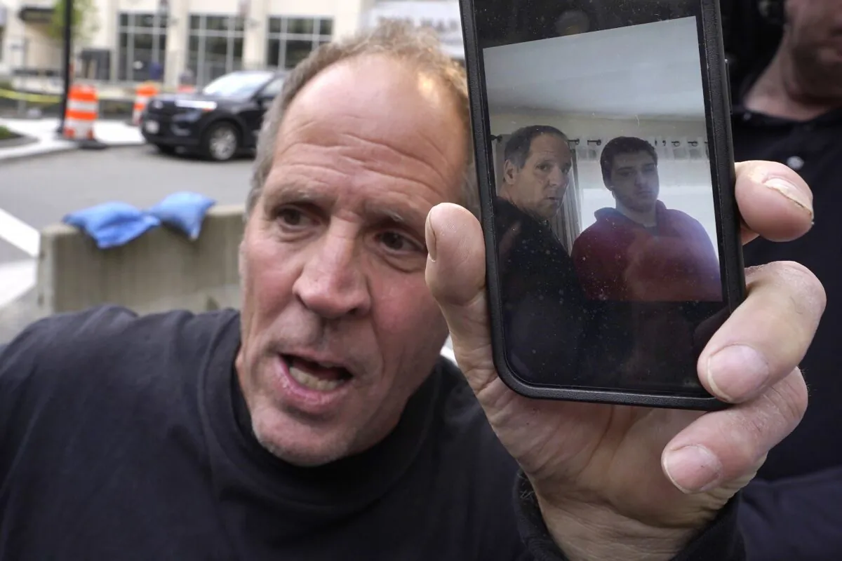 Paul Ventura (L), father of 18-year-old Mateo Ventura, displays a photograph on his cell phone that shows what he describes as a photo of himself (center L) and his son Mateo (R) while speaking with reporters outside federal court in Worcester, Mass., on June 8, 2023. (Steven Senne/AP Photo)