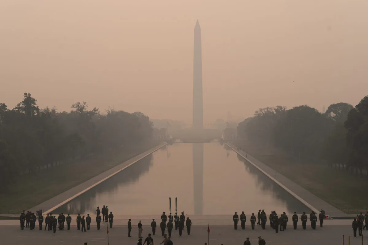 With the Washington Monument in the background and a thick layer of smoke, the Marine Corps honor color guard rehearses in Washington, D.C., on June 8, 2023. (AP Photo/Jose Luis Magana)