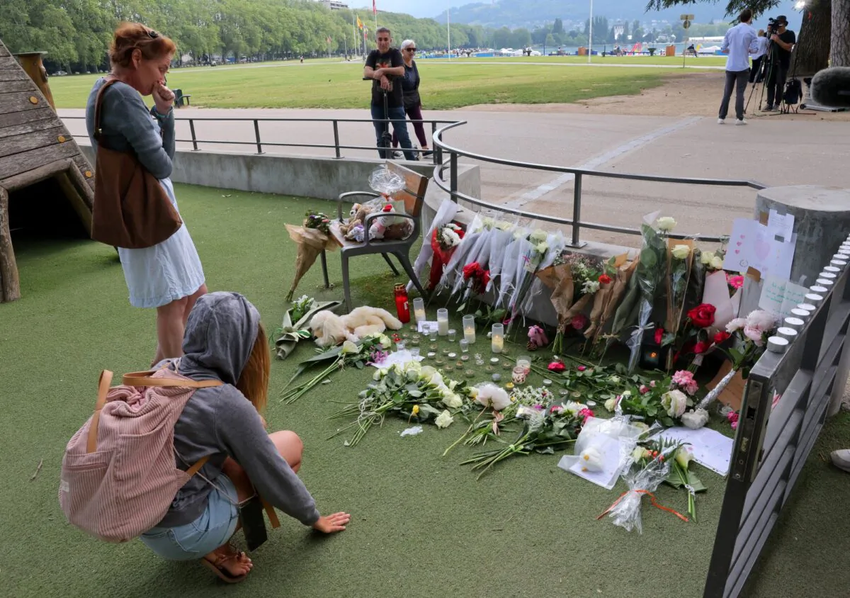 People pay respect in front of messages and floral tributes at the children's playground the day after several children and adults were injured in a knife attack at the Le Paquier park near the lake in Annecy, in the French Alps, France, on June 9, 2023. (Denis Balibouse/Reuters)