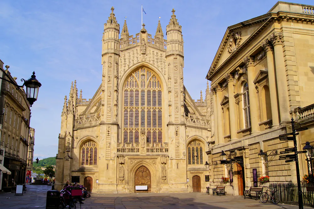 Bath Abbey rises majestically in the historic town square of Bath, in Somerset, England. Like most buildings in the city, such as the Roman baths located on the right, the abbey was built with local Bath stone, a pale yellow limestone. Most of the abbey’s exterior dates from the 1500s, including the carved statues, the wooden front door, the arched windows, and the flying buttresses. However, the decorative pinnacles were only added in the 1830s. (JeniFoto/Shutterstock)