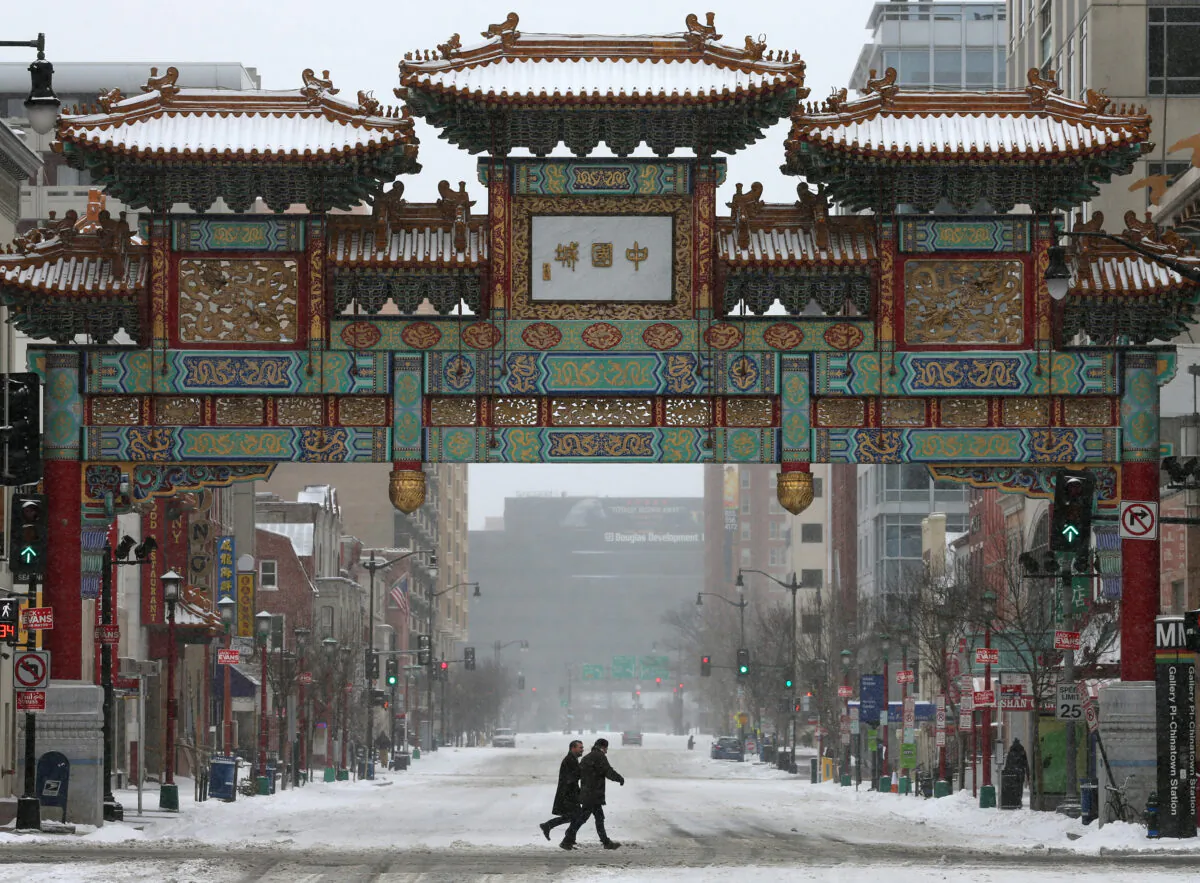 People walk in the snow near the China Town arch, or China Gate, in Washington on March 3, 2014. (Mark Wilson/Getty Images)