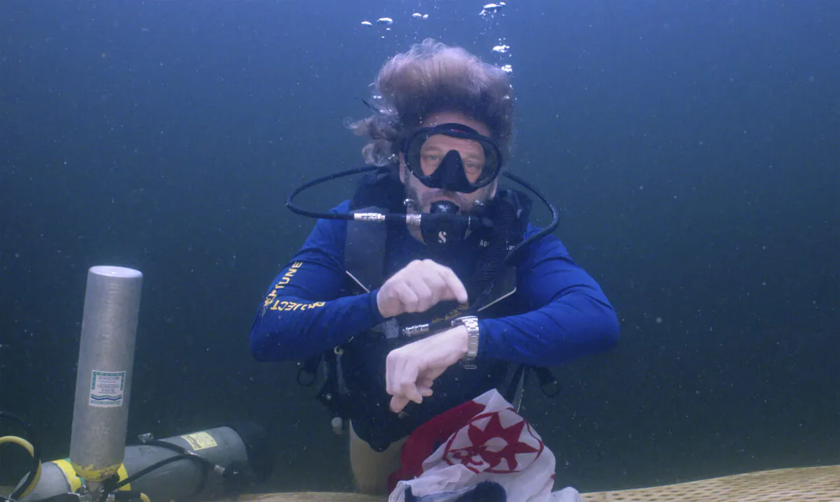 Diving explorer and medical researcher Dr. Joseph Dituri points to his watch after spending 100 days in the Jules' Undersea Lodge marine habitat at the bottom of a Key Largo, Fla., lagoon on June 9, 2023. (Mariano Lorde/Florida Keys News Bureau via AP)