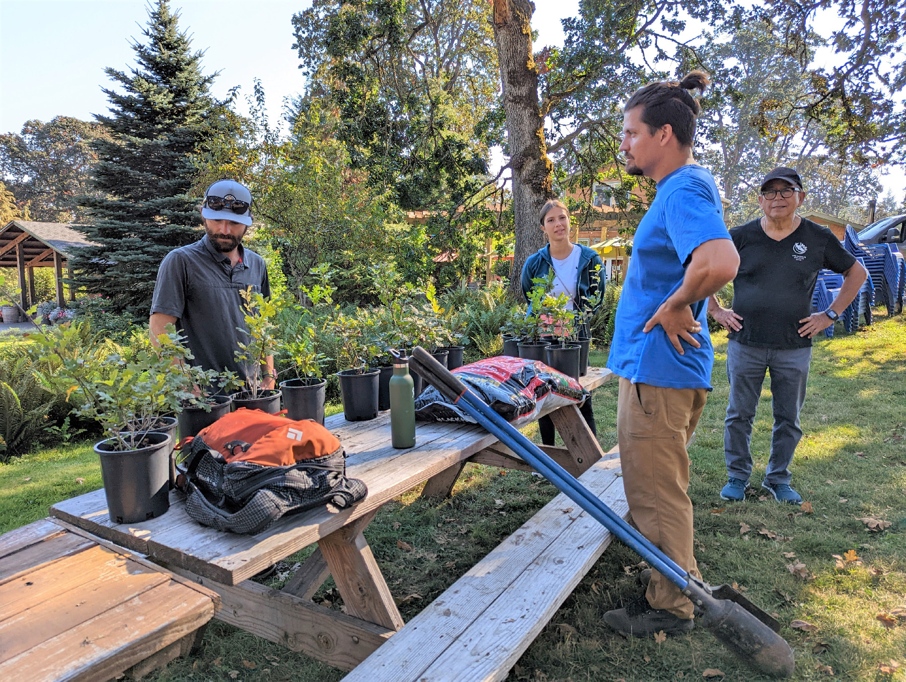 Left Coast Winery CEO Taylor Pfaff (wearing the blue T-shirt) talks with stewardship project participants as they prepare to plant white oak saplings in Rickreall, Oregon.