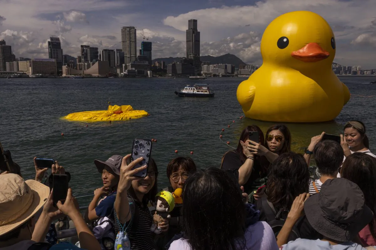 An art installation called "Double Ducks" by Dutch artist Florentijn Hofman as one of the duck is deflated at Victoria Harbour in Hong Kong on June 10, 2023. (Louise Delmotte/AP Photo)