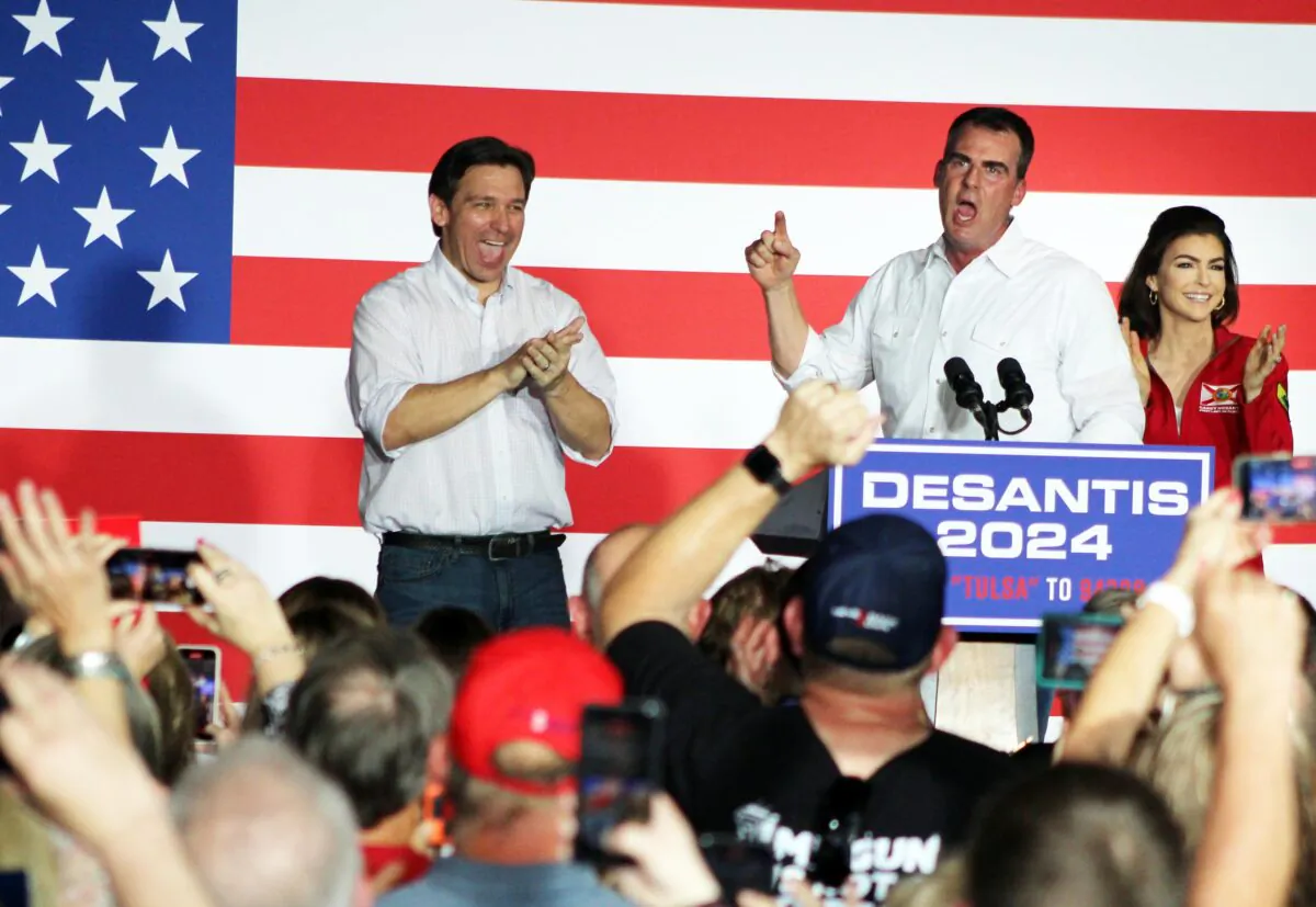 Oklahoma Gov. Kevin Stitt (center) endorses Florida Gov. Ron DeSantis (left) for the Republican nomination for president as DeSantis' wife Casey looks on during a rally in Tulsa, Okla., on June 10, 2023. (Michael Clements/The Epoch Times)