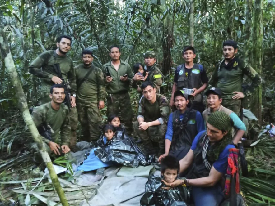 Soldiers and Indigenous men pose for a photo with the four Indigenous children who were missing after a deadly plane crash, in the Solano jungle, Caqueta state, Colombia, on June 9, 2023. (Colombia's Armed Force Press Office via AP)
