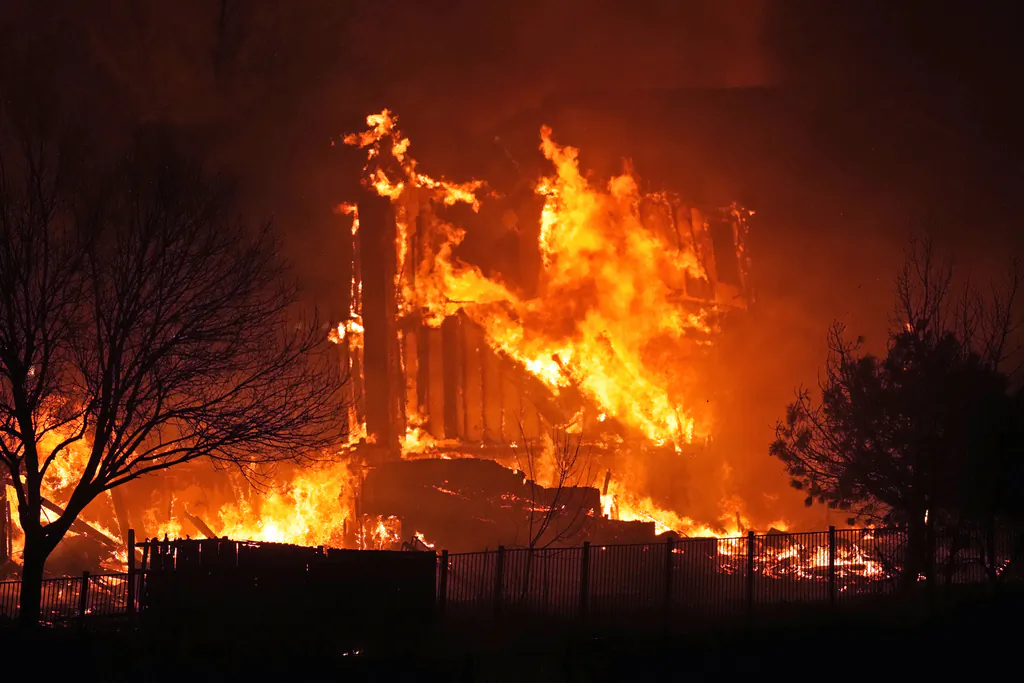 Homes burn as a wildfire rips through a development near Rock Creek Village, near Broomfield, Colo. on Dec. 30, 2021. (David Zalubowski/AP Photo, File) 
