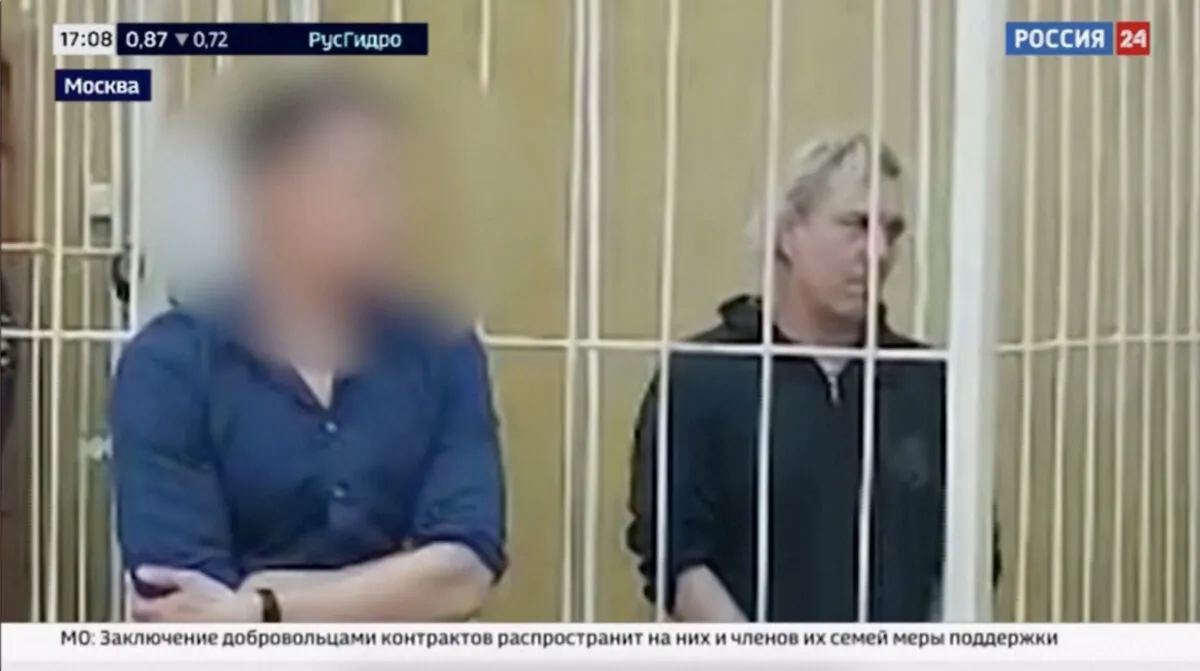 Martin Travis Leake (R), standing in a metal cage, appears in court in Moscow in a still from video released by Russian state TV on June 10, 2023. (RURTR via Reuters/Screenshot via The Epoch Times)