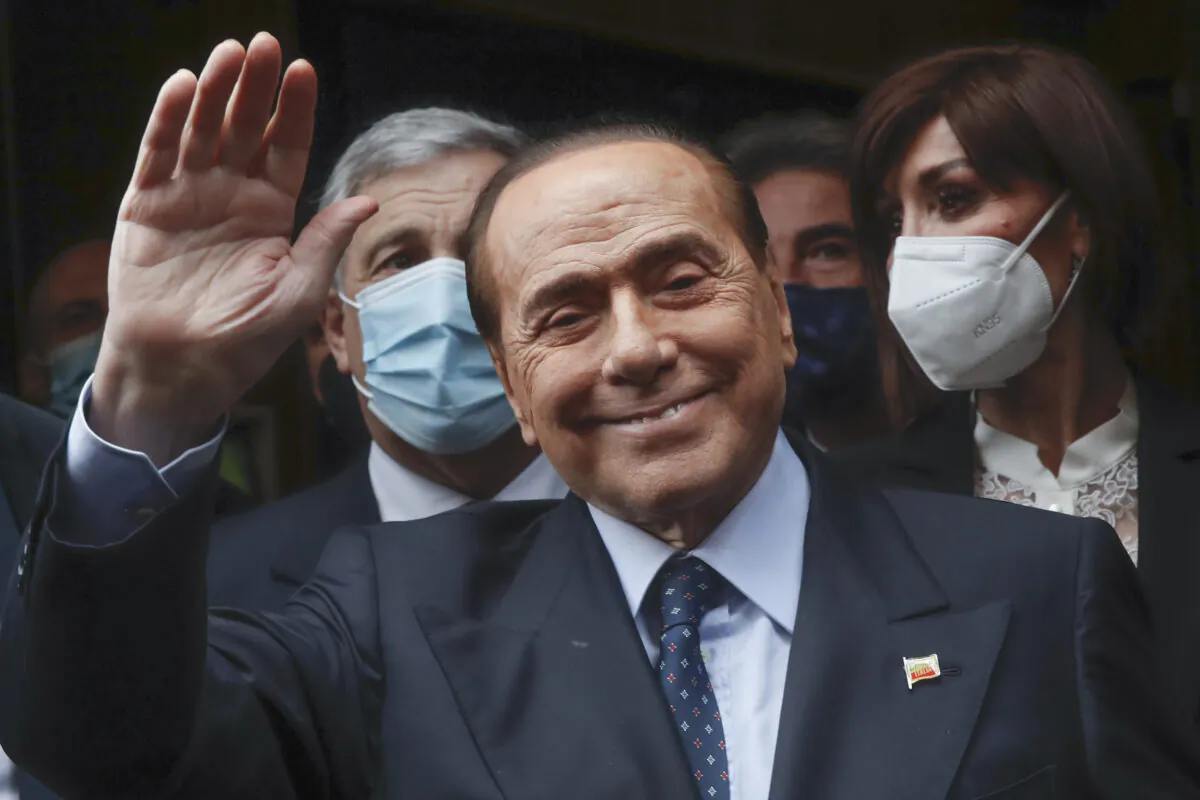 Former Italian Premier Silvio Berlusconi waves to reporters as he arrives at the Chamber of Deputies to meet Mario Draghi, in Rome, on Feb. 9, 2021.  (Alessandra Tarantino/AP Photo)

