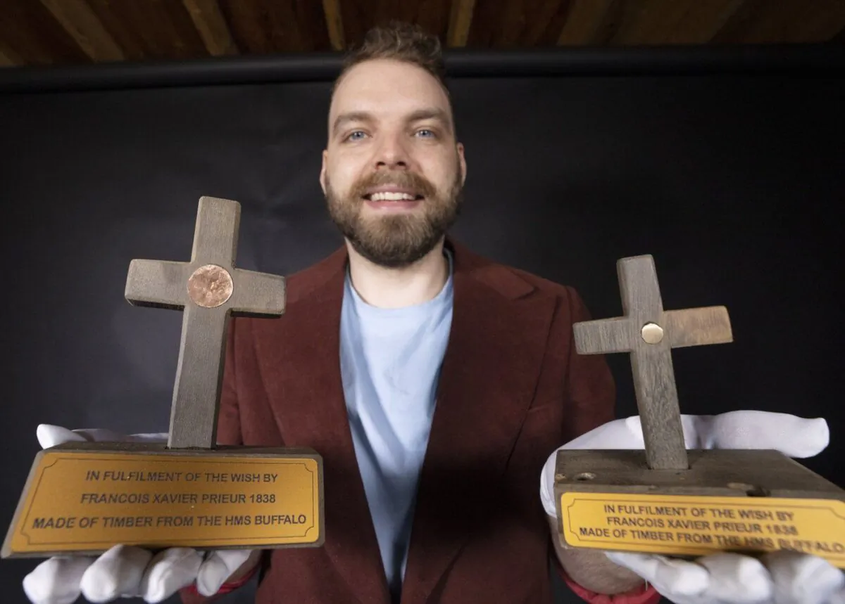 Sam Pineault holds a pair of wooden crosses made from a shipwreck in New Zealand in his studio in St. Jean-Sur-Richelieu, Que., June 9, 2023. (The Canadian Press/Ryan Remiorz)
