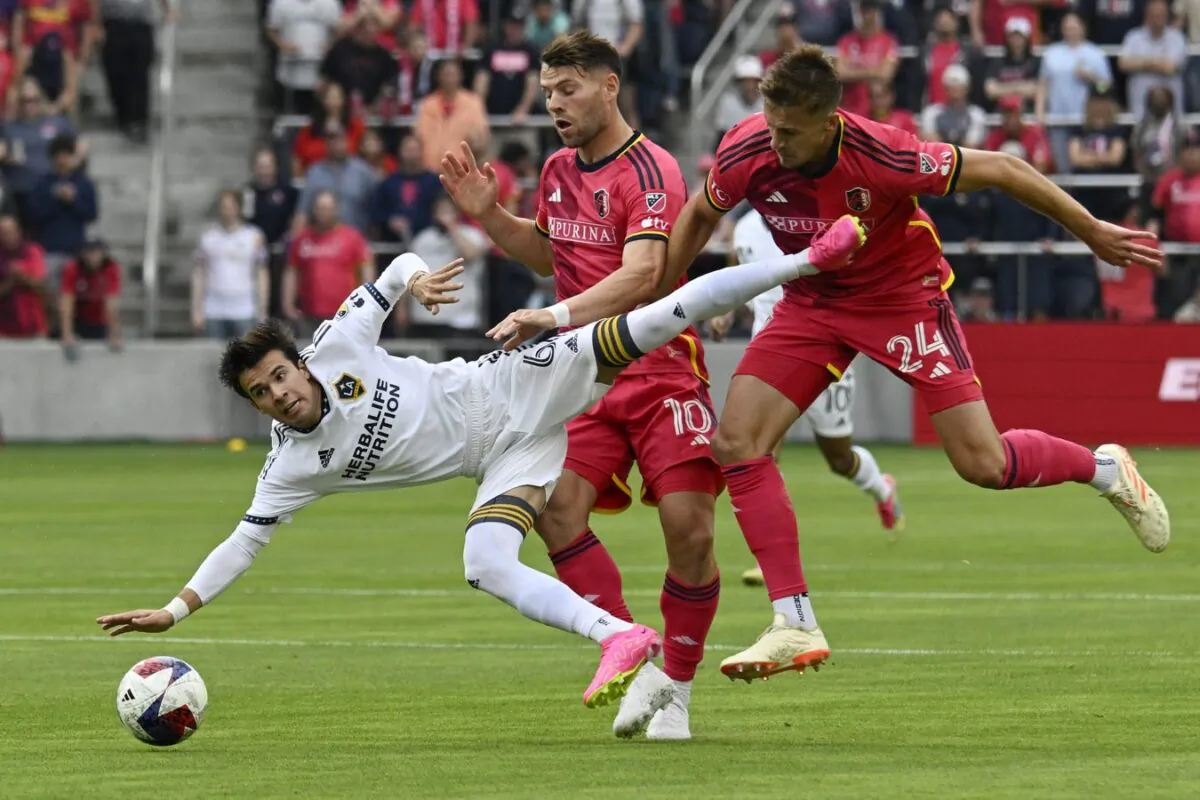 Los Angeles Galaxy midfielder Riqui Puig (6) and St. Louis City midfielder Eduard Lowen (10) and defender Lucas Bartlett (24) collide in the first half at CITYPARK in St. Louis on June 11, 2023. (Scott Rovak/USA TODAY Sports via Field Level Media)