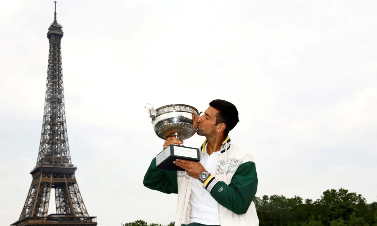 Serbia's Novak Djokovic kisses the trophy in front of the Eiffel Tower after winning the men's singles French Open title in Roland Garros, Bir-Hakeim Bridge, Paris on June 12, 2023. (Clodagh Kilcoyne/Reuters)