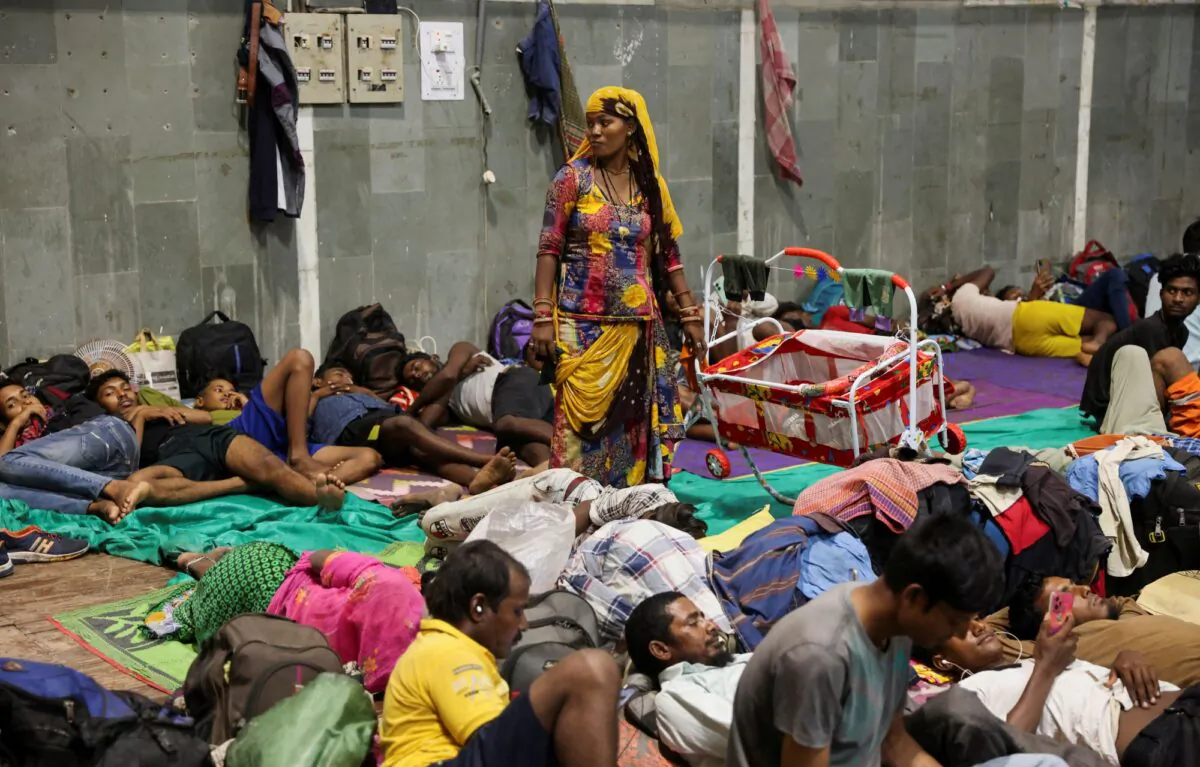 Laxmi Kumar pushes a cradle carrying her three year old son Arvind at a temporary shelter for people evacuated from Kandla port, before the arrival of cyclone Biparjoy, in Gandhidham, in the western state of Gujarat, India, on June 13, 2023. (Francis Mascarenhas/Reuters)