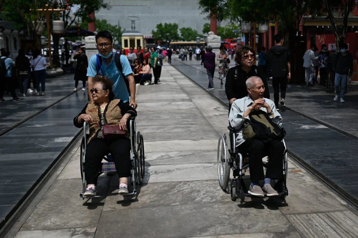 Senior citizens are pushed along a street in Beijing on May 11, 2021. (Wang Zhao/AFP via Getty Images)