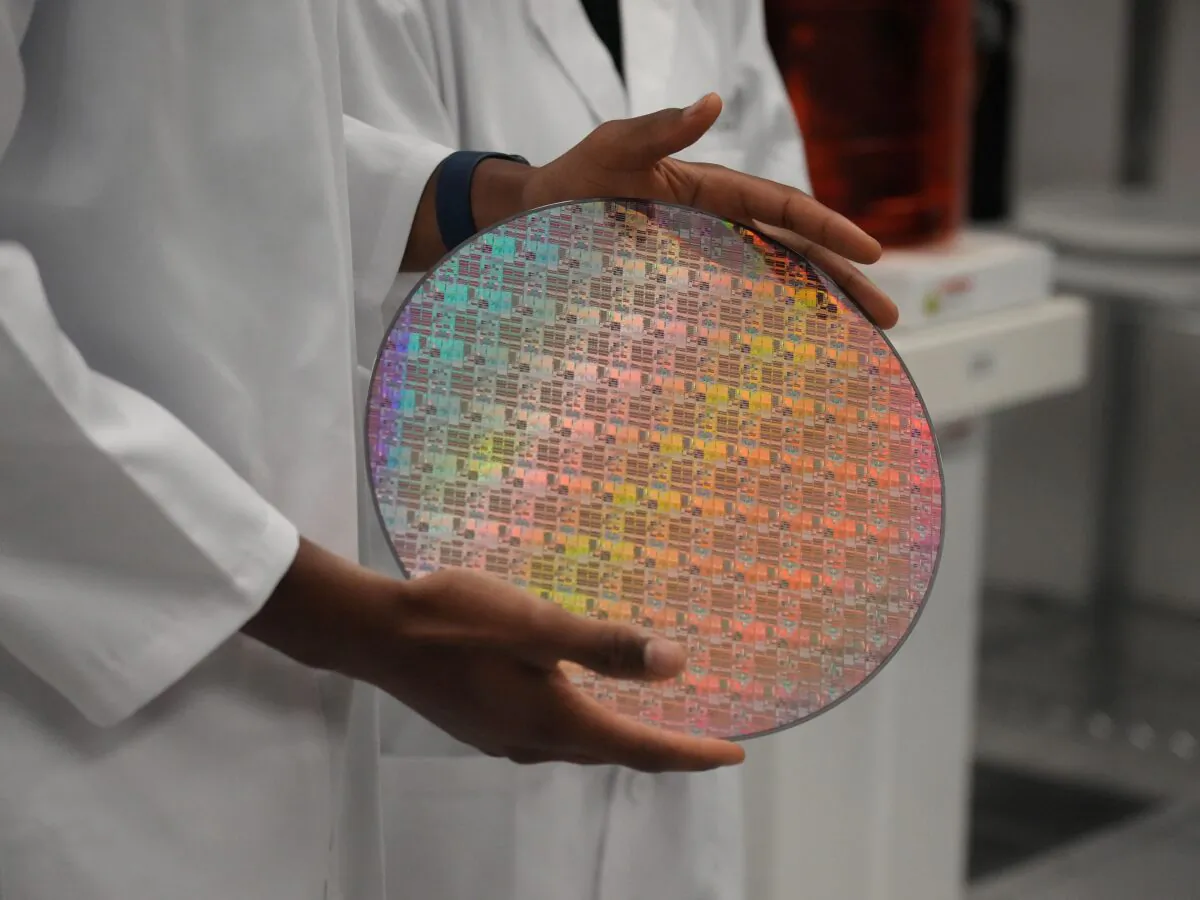 An employee holds a silicon wafer with chips etched into it at Applied Materials in Sunnyvale, Calif., on May 22, 2023. (Jim Wilson/Pool/AFP via Getty Images)