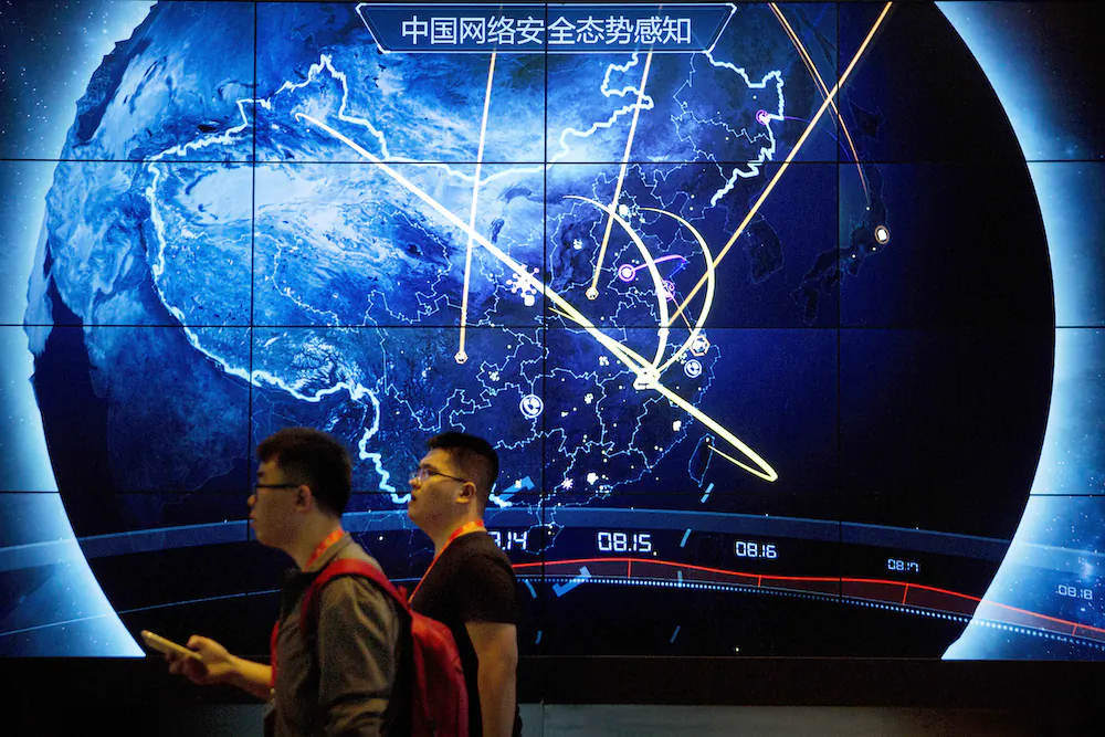 Attendees walk past an electronic display showing recent cyberattacks in China at the China Internet Security Conference in Beijing on Sept. 12, 2017. (Mark Schiefelbein/AP Photo)