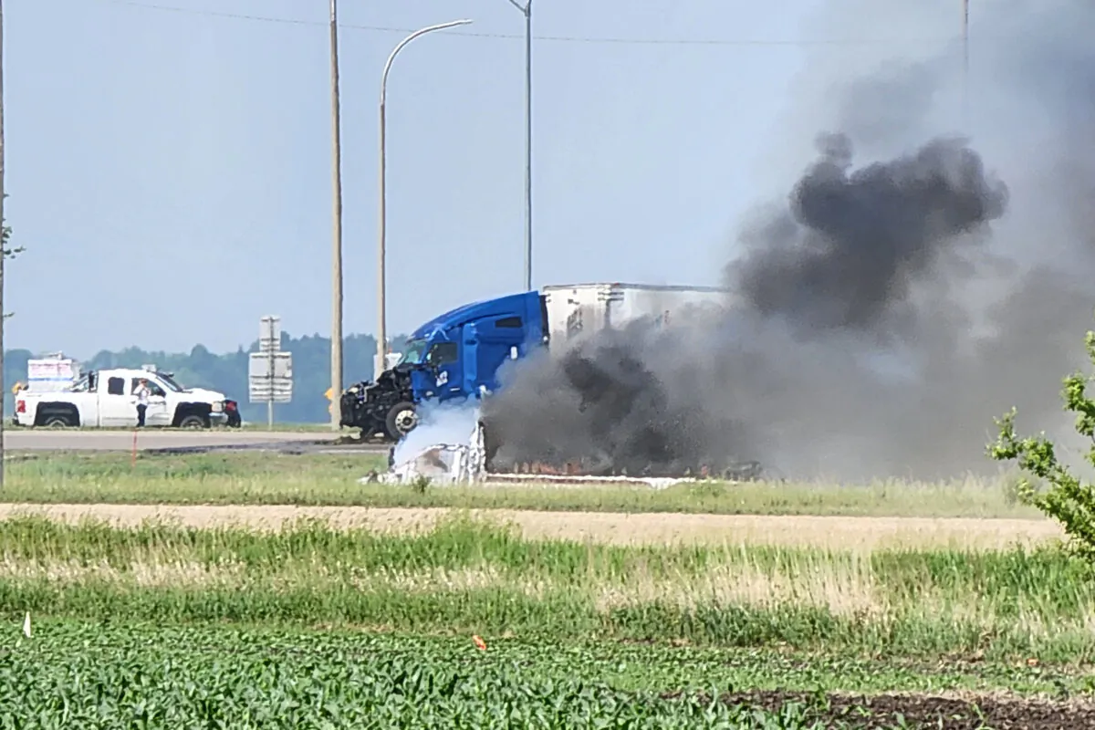Smoke comes out of a car following a road accident that left 15 dead near Carberry, west of Winnipeg, on June 15, 2023. (Nirmesh Vadera/AFP via Getty Images)
