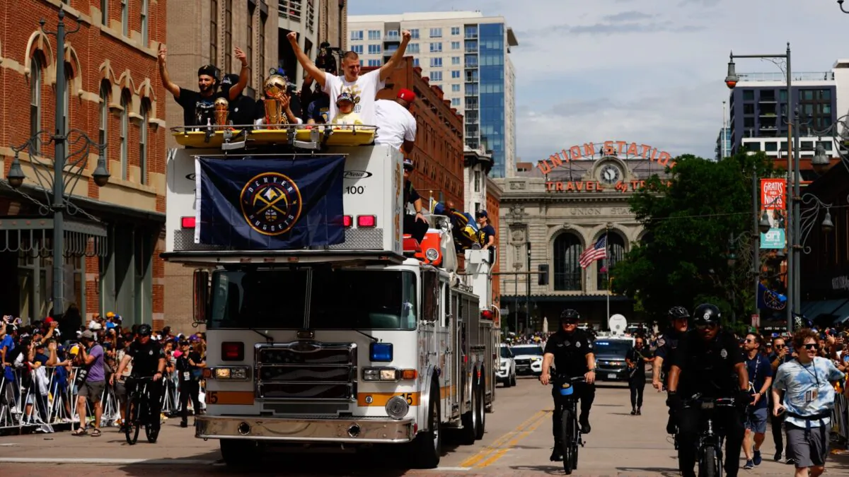 Jamal Murray #27 and Nikola Jokic #15 wave to fans with the Larry O'Brien Championship Trophy during the Denver Nuggets victory parade and rally after winning the 2023 NBA Championship in Denver, Colo., on June 15, 2023. (Justin Edmonds/Getty Images)
