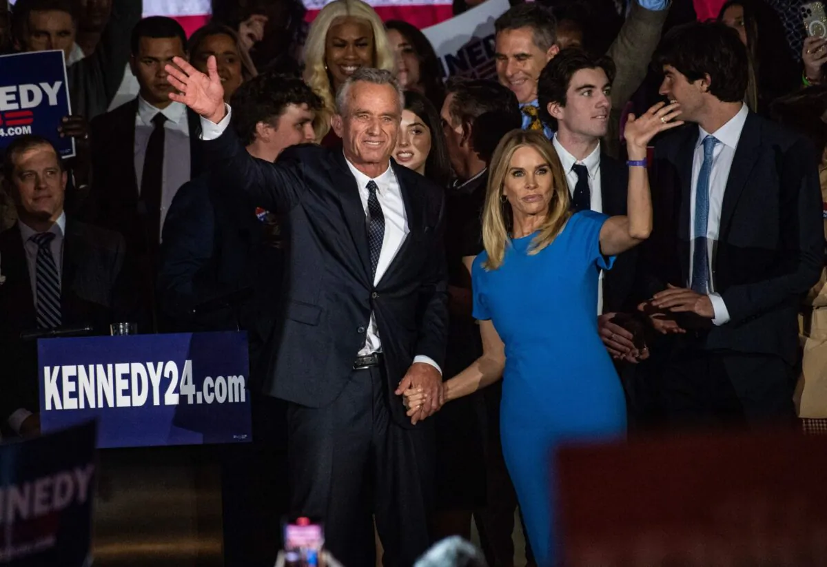Robert F. Kennedy Jr. and his wife, Cheryl Hines, wave to supporters during a campaign event to launch his 2024 presidential bid, at the Boston Park Plaza in Boston on April 19, 2023. (Joseph Prezioso/AFP via Getty Images)
