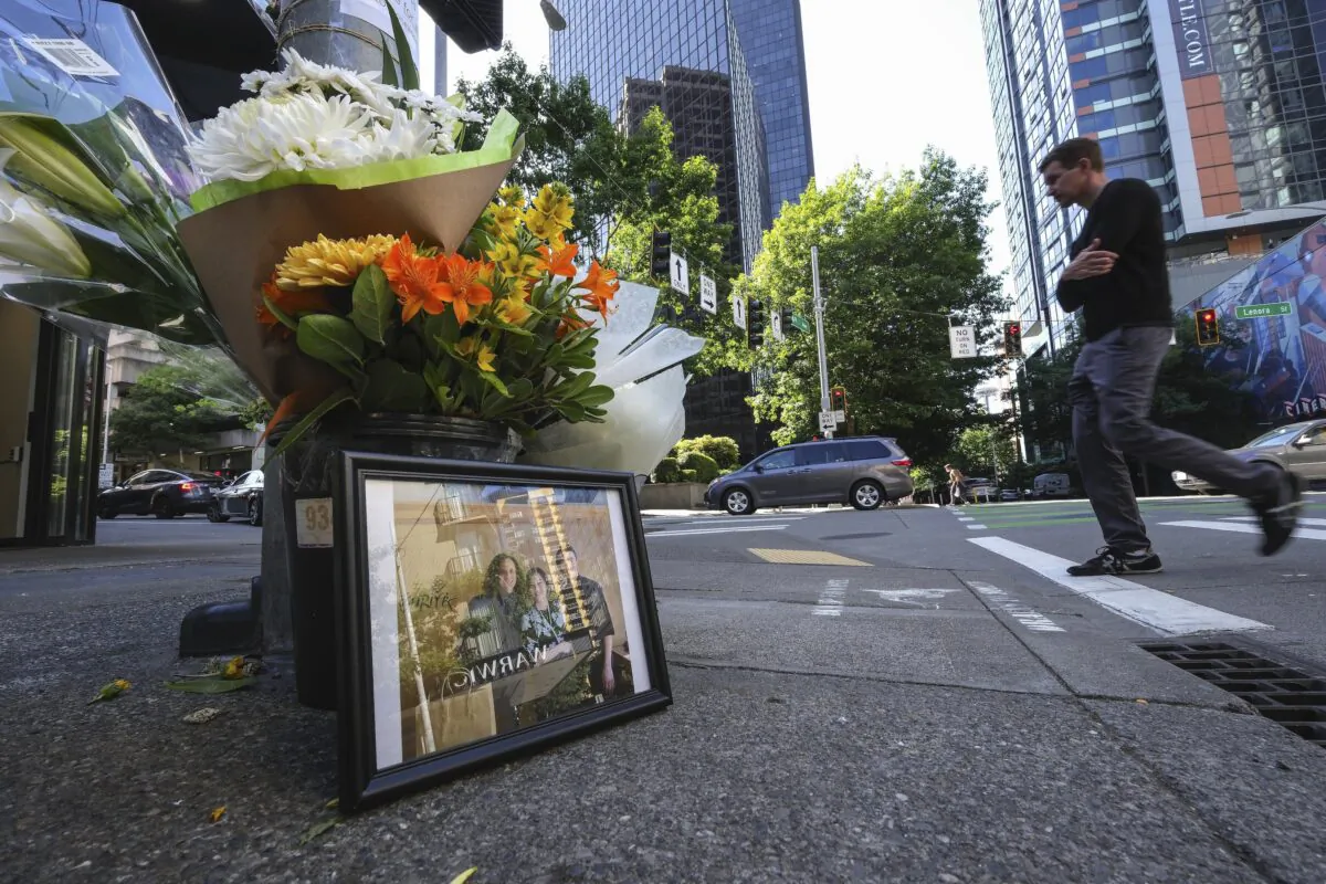 A bouquet of flowers and a photograph sits on the corner of Lenora St. and 4th Avenue in Seattle on June 15, 2023 (Dean Rutz/The Seattle Times via AP)