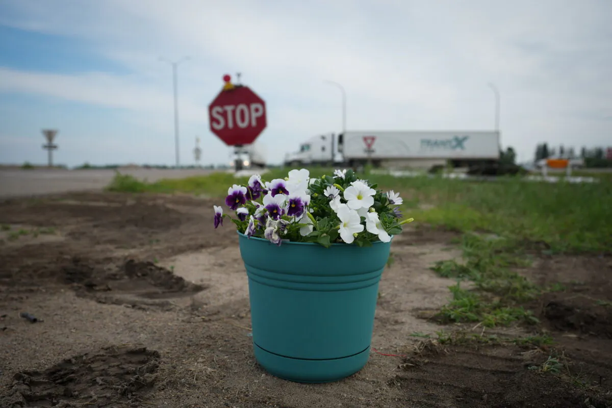 Flowers are seen on the side of the road where the Trans-Canada highway intersects with Hwy 5 near Carberry, Man., on June 16, 2023, where a semi and a bus collided on June 15. (Darryl Dyck/The Canadian Press)