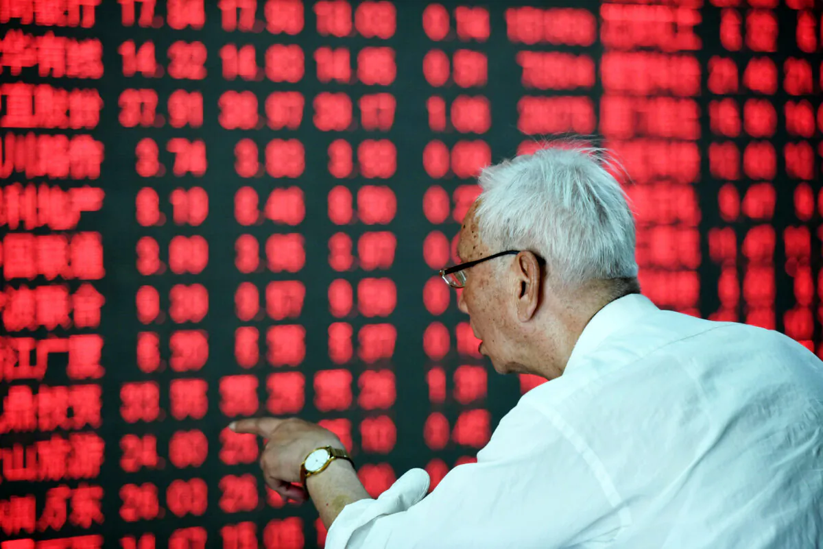 A Chinese investor gestures in front of a screen showing stock market movements at a securities firm in Hangzhou, eastern China's Zhejiang province, in a file photo. (STR/AFP via Getty Images)