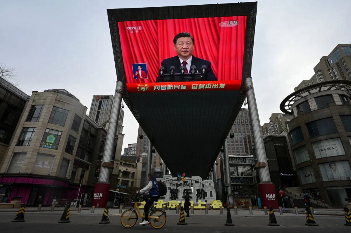 An outdoor screen shows a live news coverage of Chinese leader Xi Jinping delivering a speech along a street in Beijing on March 13, 2023. (Jade Gao/AFP via Getty Images)