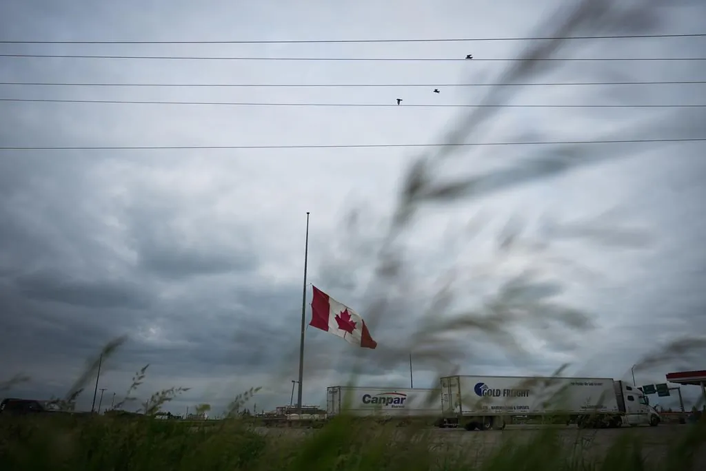 A Canadian flag flies at half-mast at a truck stop in Brandon, Man., on June 16, 2023, to honour the victims of a bus crash in Carberry, on the Trans-Canada Highway west of Winnipeg. (The Canadian Press/Darryl Dyck)