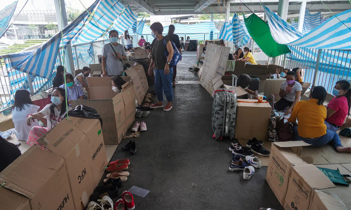 Foreign domestic helpers group stayed on the skybridge to take a rest with their weekend in Hong Kong on May 29, 2023. (Adrian Yu/Epochtimes)