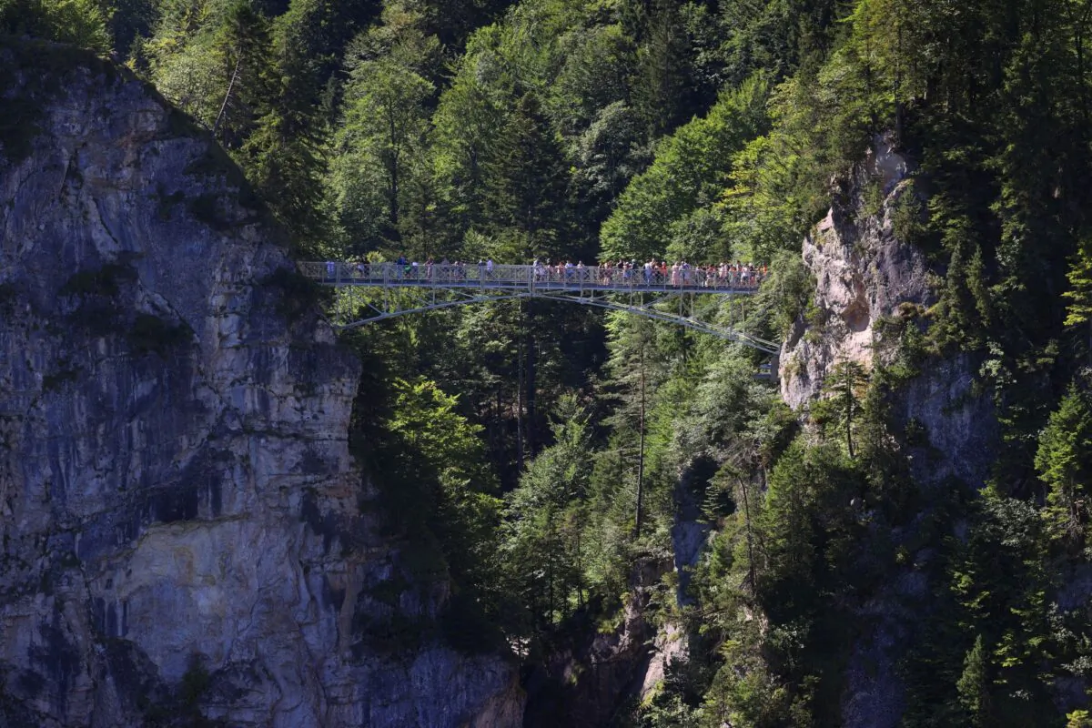 Tourists stand on the Marienbr'cke bridge, near the Neuschwanstein castle, in Schwangau, Germany, on June 15, 2023. (Frank Rumpenhorst/dpa via AP)