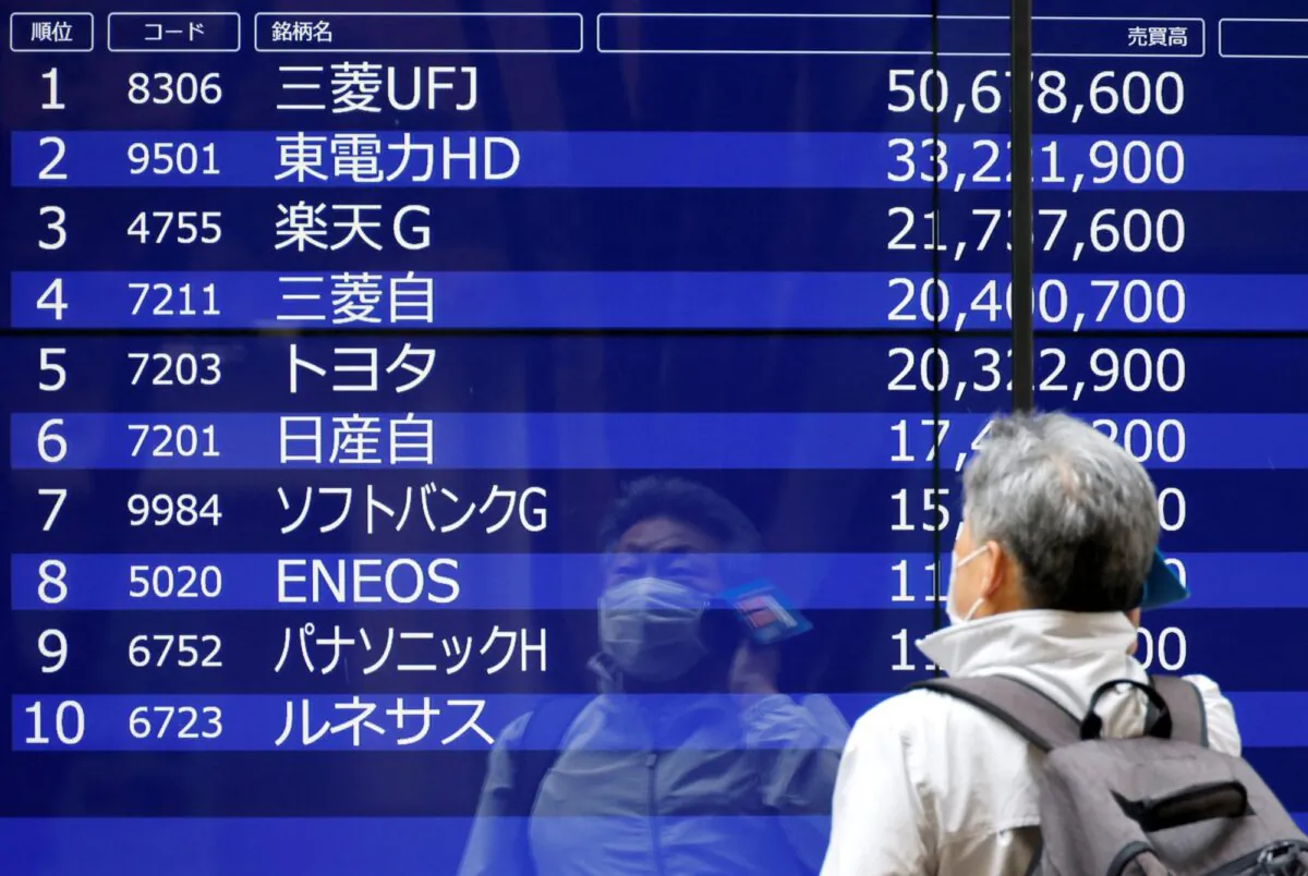 A man is reflected on an electric monitor displaying a stock quotation board outside a bank in Tokyo, Japan, on June 5, 2023. (Issei Kato/Reuters)