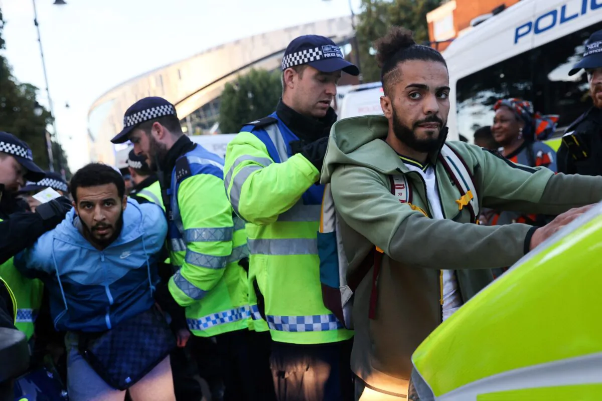 Police officers stop and conduct searches on football supporters arriving to attend the UEFA Champions League Group D football match between Tottenham and Olympique de Marseille, at the Tottenham Hotspur Stadium, in London, on Sept. 7, 2022. (Adrian Dennis/AFP via Getty Images)