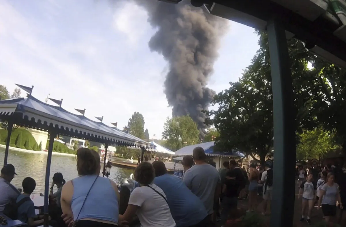 Visitors look at smoke that raises above the 'Europa-Park' in Rust, Germany on June 19, 2023. (zema-medien/dpa via AP)
