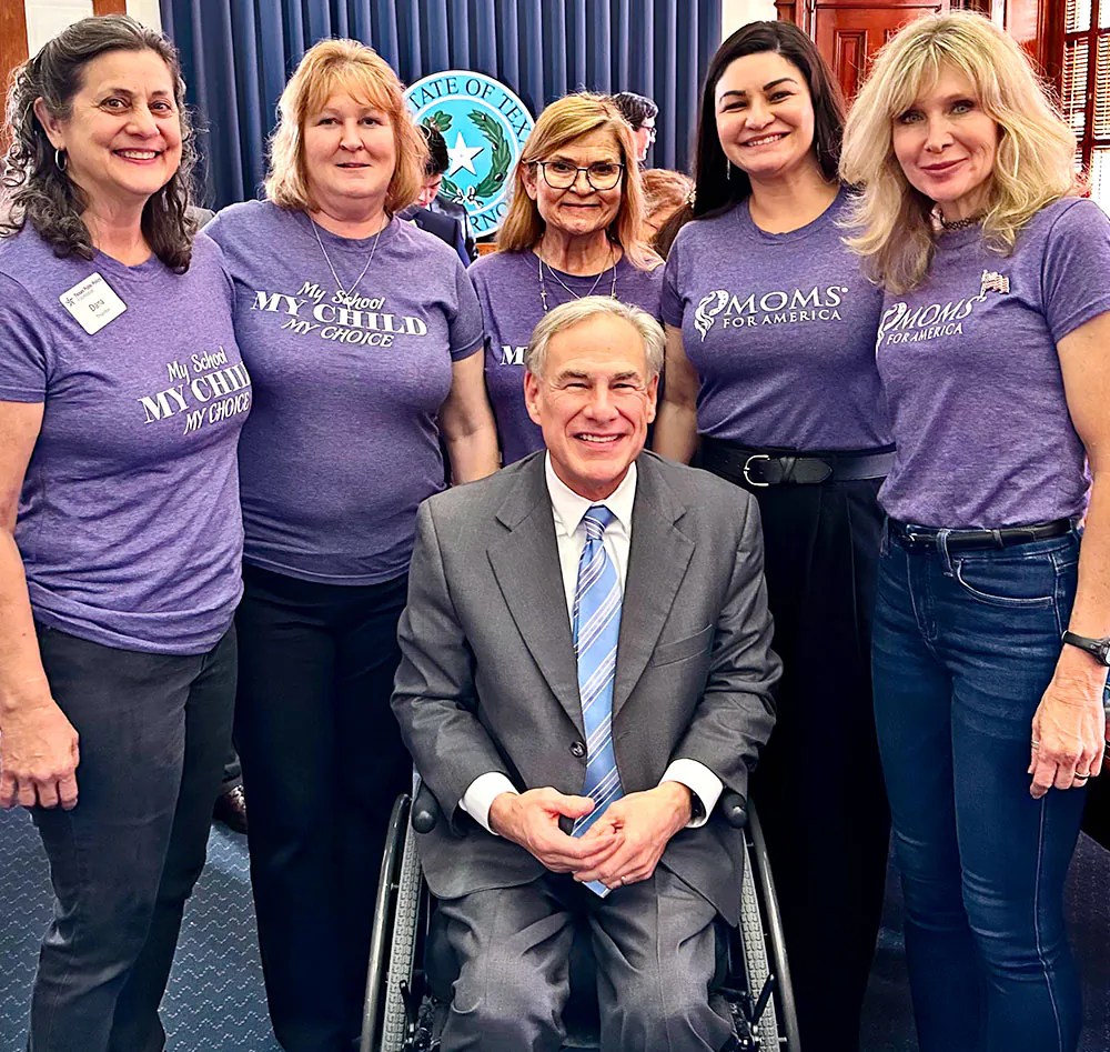 Texas Gov. Greg Abbott (C) poses for a photo with members of Moms for America on April 11, 2023. (Courtesy of Moms for America)