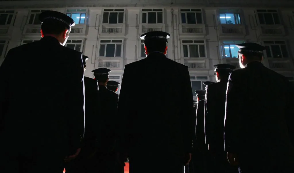 Policemen take part in a raid on entertainment venues in Beijing on Oct. 25, 2006. The raid is part of Beijing police's efforts to crackdown on drug abuses, gambling, and prostitution at entertainment venues in the Chinese capital. (Photo by China Photos/Getty Images)