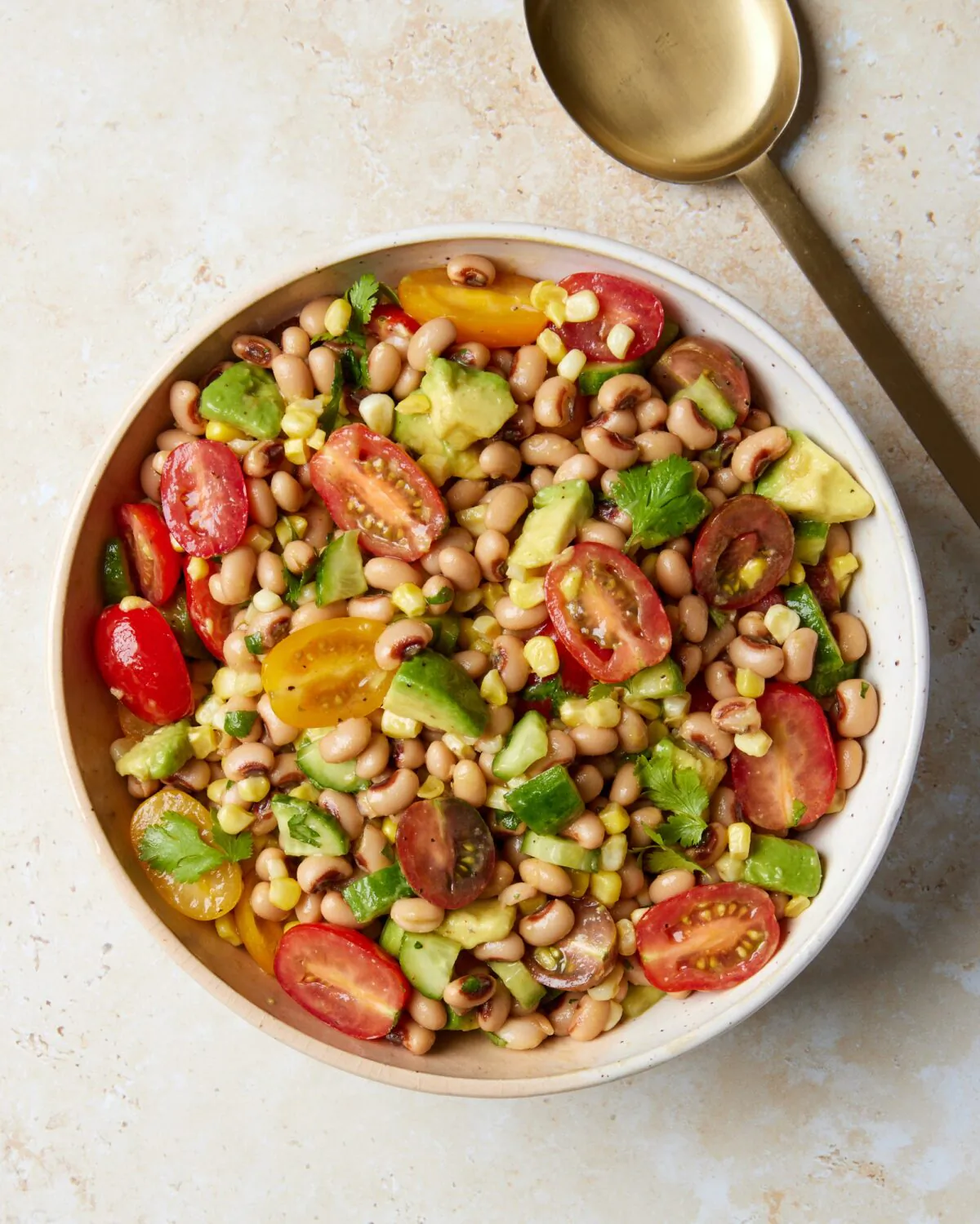 A bright summer salad with black-eyed peas, avocado, cherry tomatoes, corn, and cucumbers dressed in a punchy lime vinaigrette. (Lucy Schaffer/TNS)