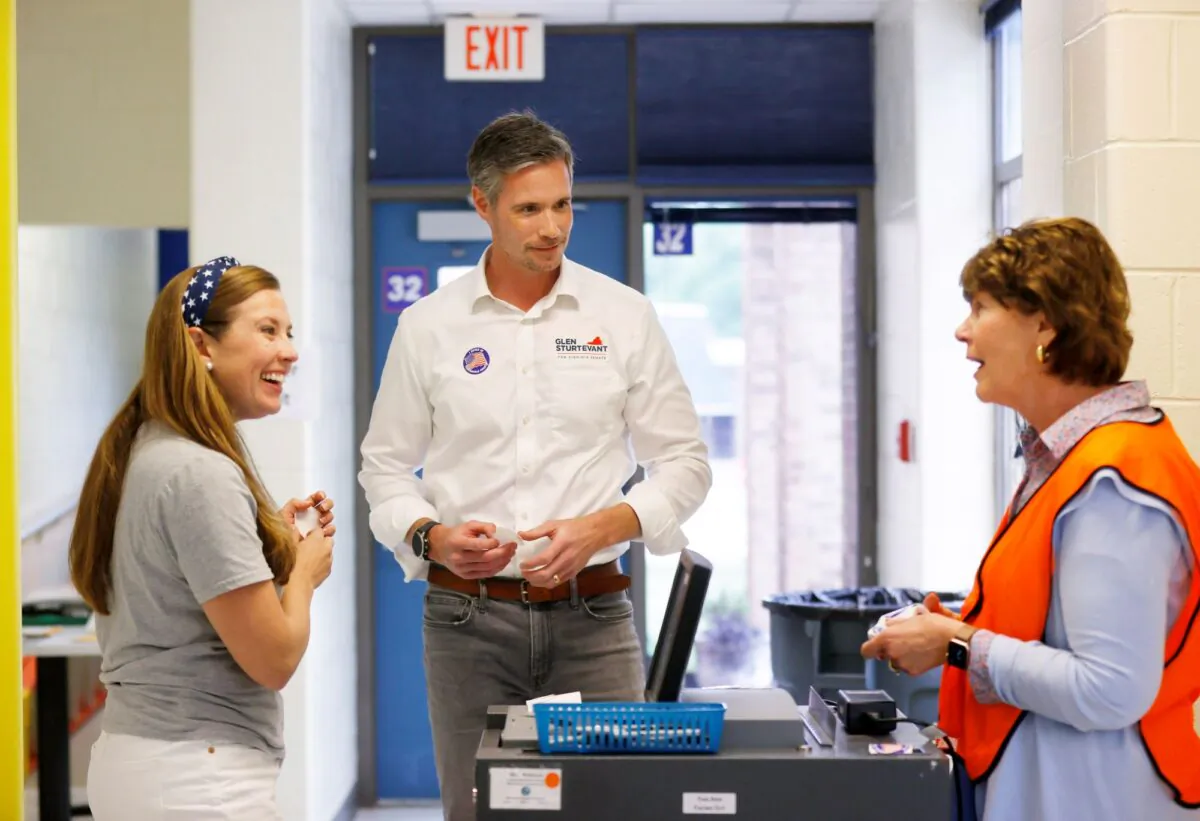 (L) Lori Cochrane Sturtevant and (C) Glen Sturtevant talk to (R) poll worker Pam Maxey after casting their ballots at Robious Elementary School in Midlothian, Va., on June 20, 2023. (Margo Wagner/Richmond Times-Dispatch via AP)